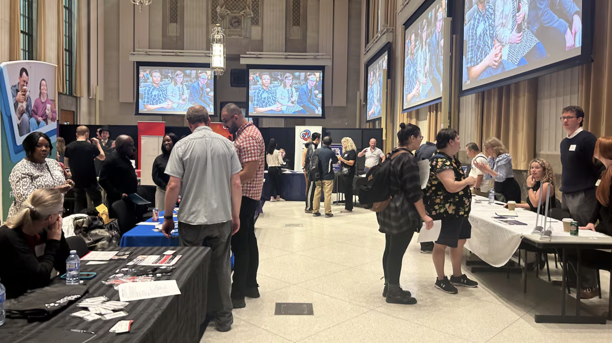 Job seekers stopping by employers' booths at a job fair